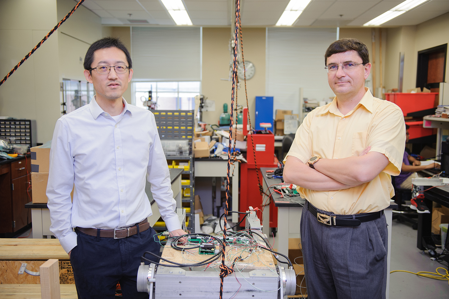 dr. shen and dr. sazzonov in a lab filled with electrical equipment