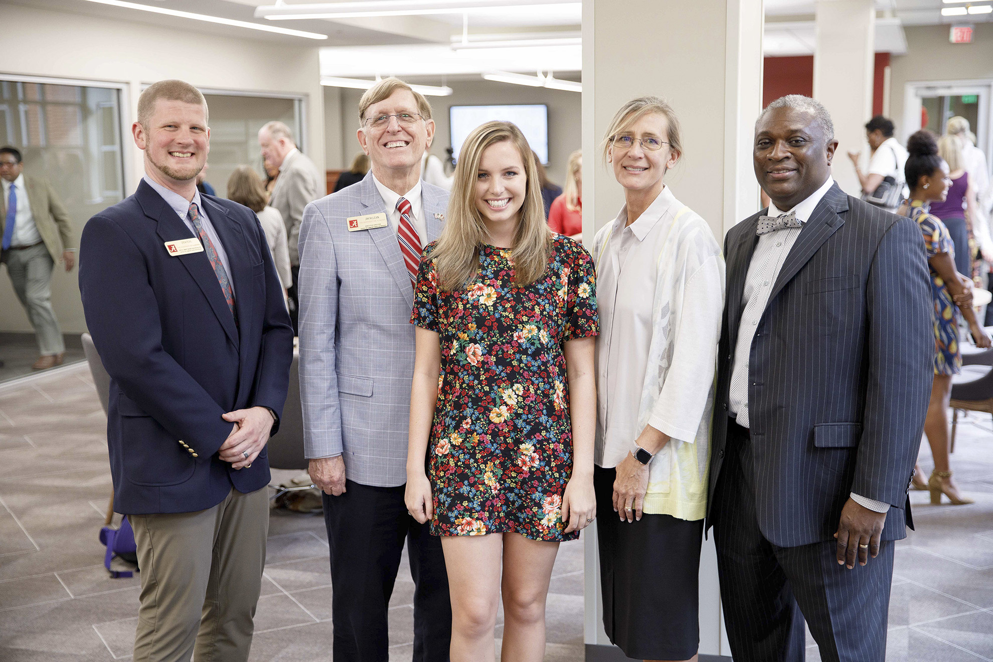 5 people pose for a photo indoors