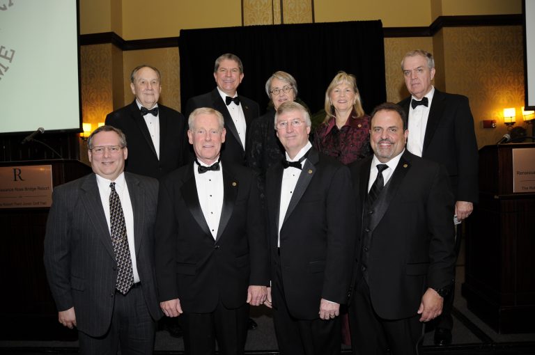 9 people in formal wear stand together indoors for the State Engineering Hall of Fame