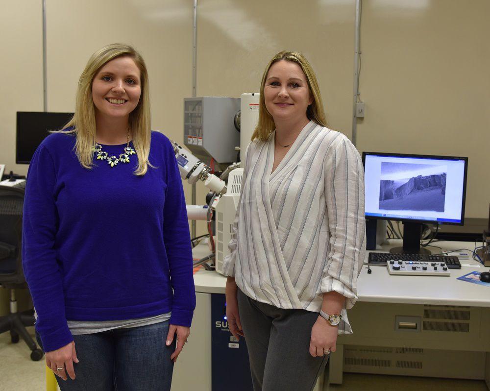Two women in a lab with a computer in the background