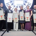 6 people in formal wear holding awards