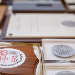 Many award and honor plaques laid out across a table