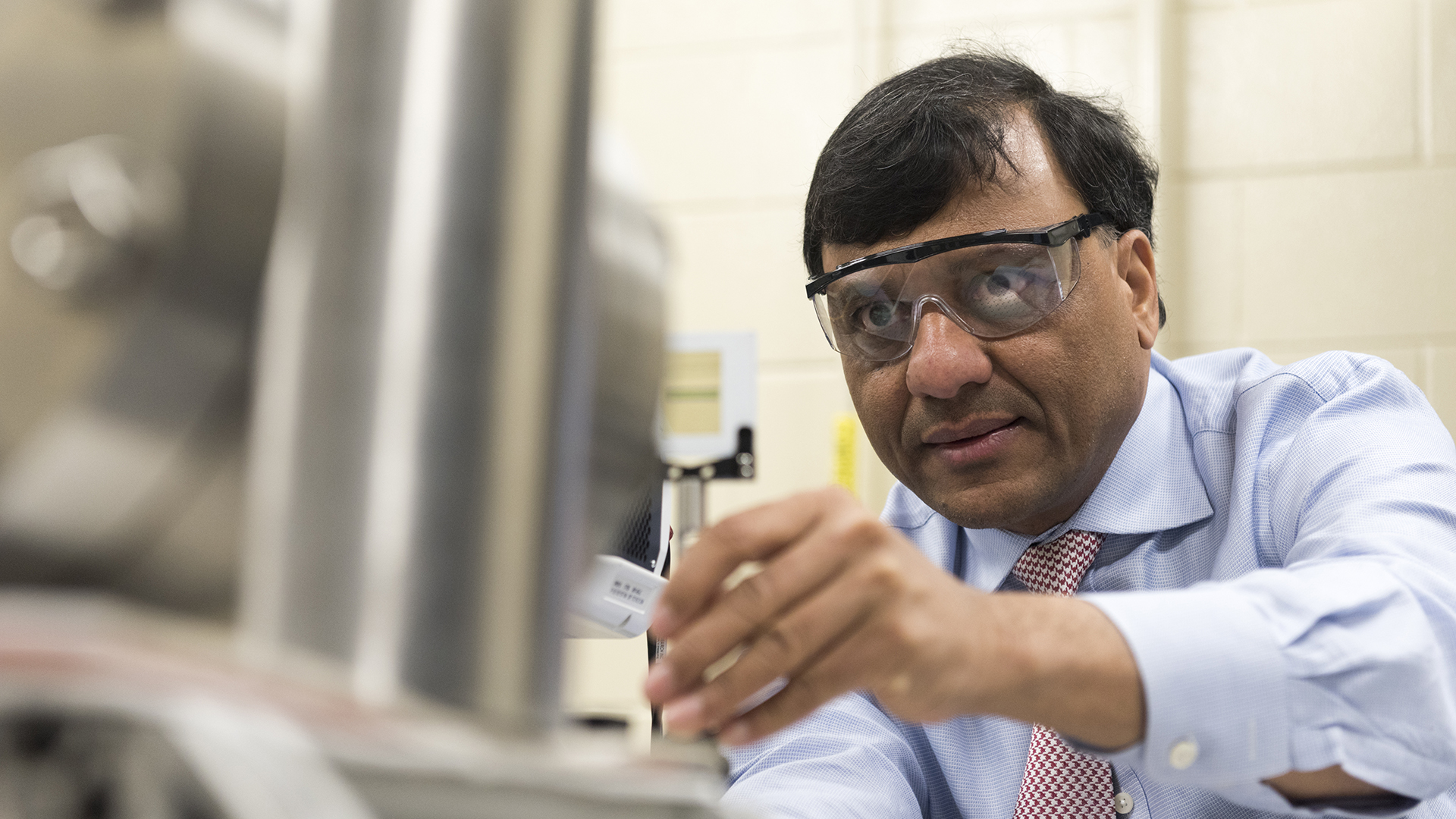 Dr. Ajay K. Agrawal working in safety goggles on some metal pipes