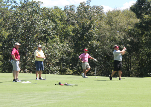 Four people on golf course on a sunny day