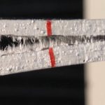 A double cantilever carbon-reinforced composite beam begins to heal itself under the actuation of macro- fiber composites after a Mode I delamination test.