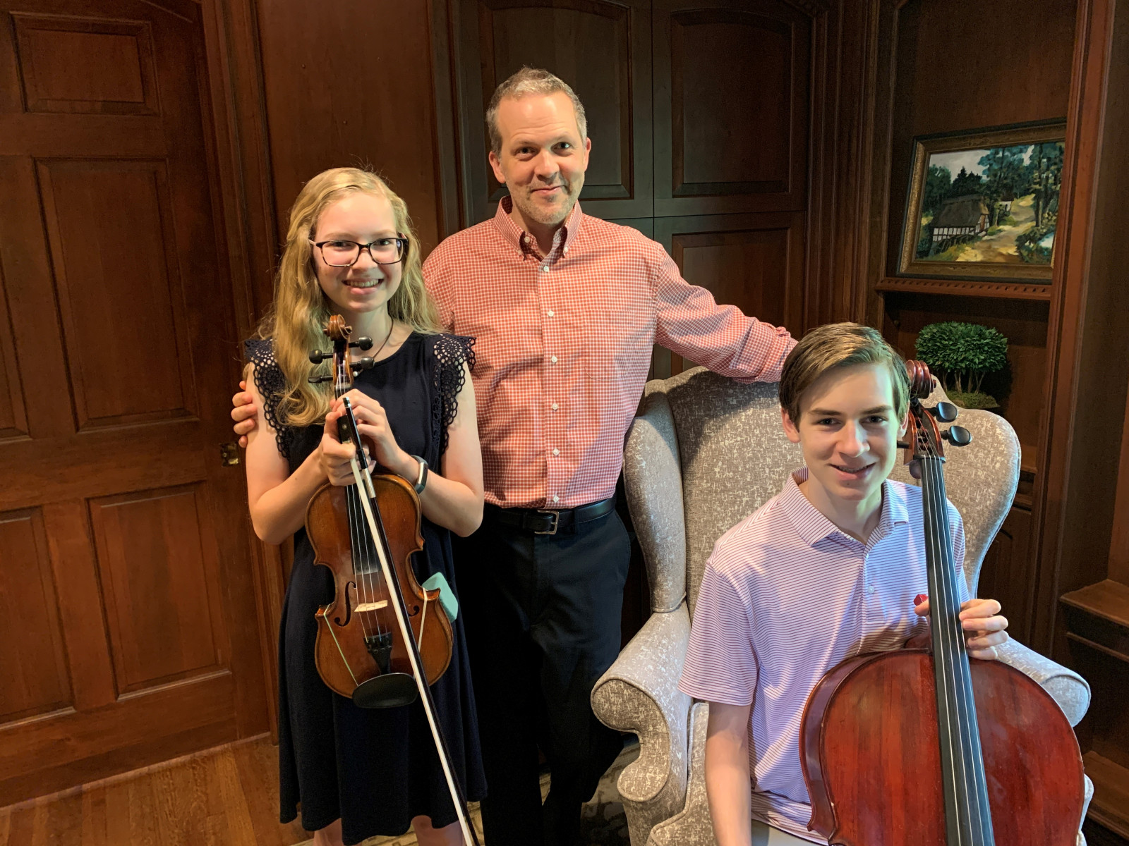 Dr. Heath Turner and children with instruments in a wood paneled room