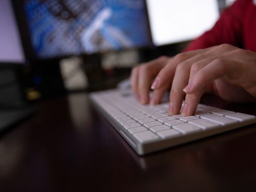 hands typing on a mac keyboard