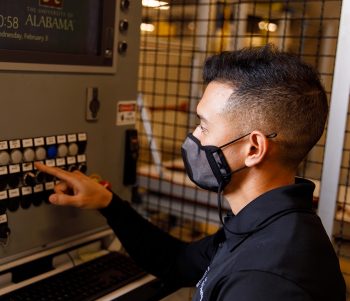 student pressing a button on a machine