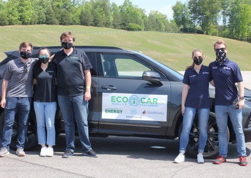 5 people stand outside next to their ecocar