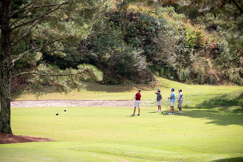 distant shot of a golf team with the sand trap behind them