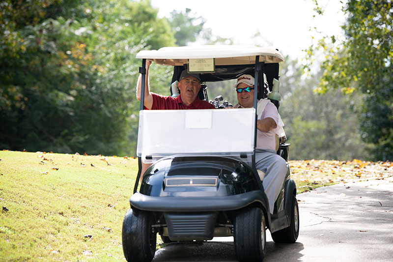 two golfers riding in a golf cart