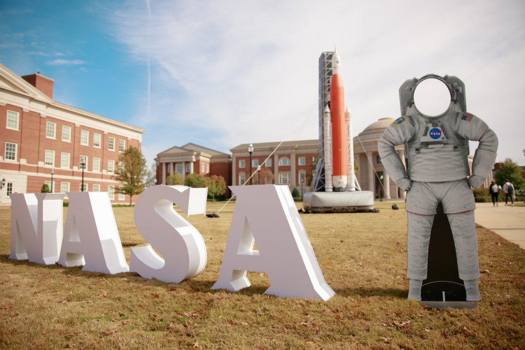 A view of the Engineering Quad with the block letters of NASA and a rocket in the distance.