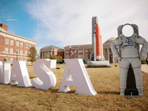 A view of the Engineering Quad with the block letters of NASA and a rocket in the distance.