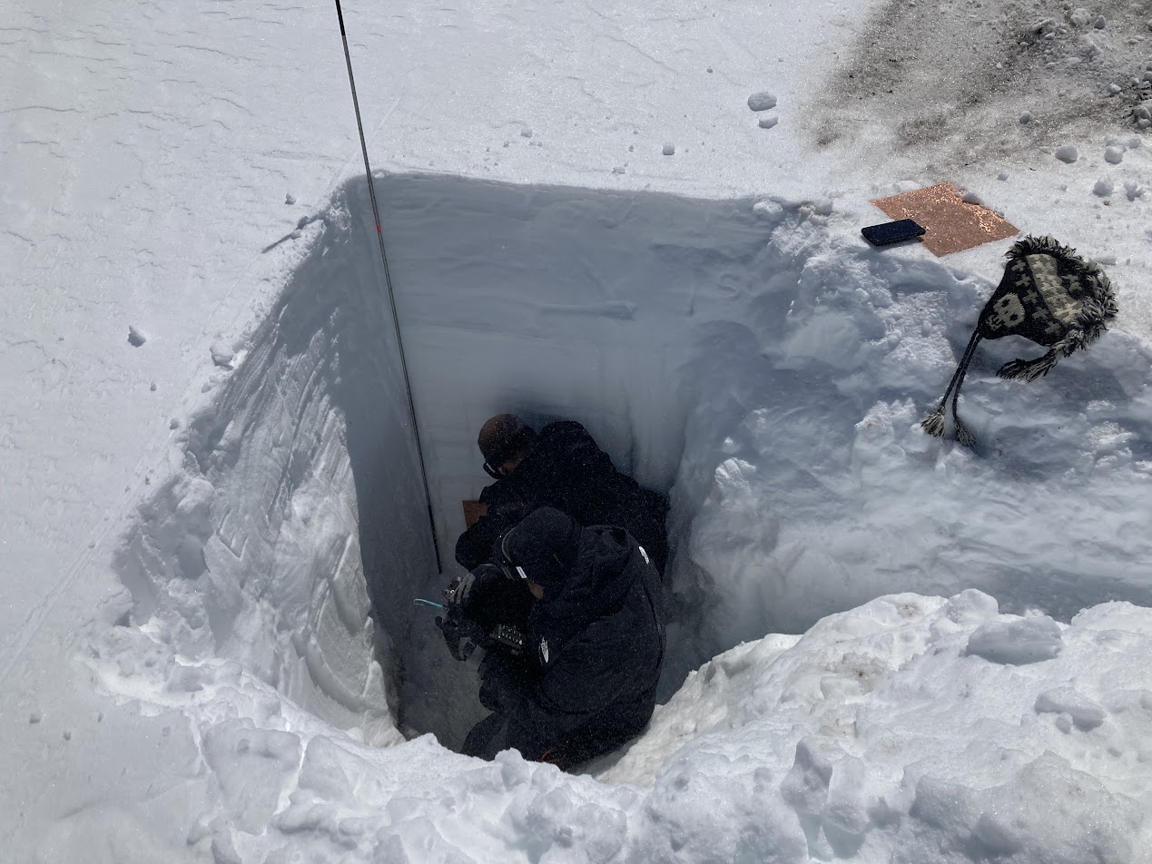 Two men in a snow hole.