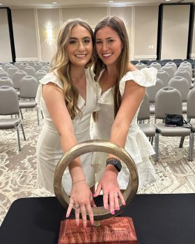 two students showing off their rings within the ring