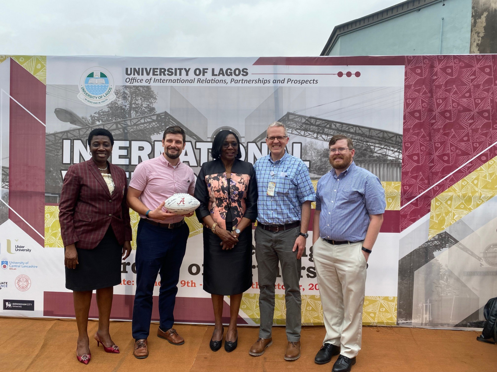 5 people in front of a University of Lagos graphic, one holding a football