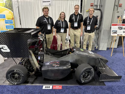 Four members of the Crimson Racing team pose with their formula car at CAMX.