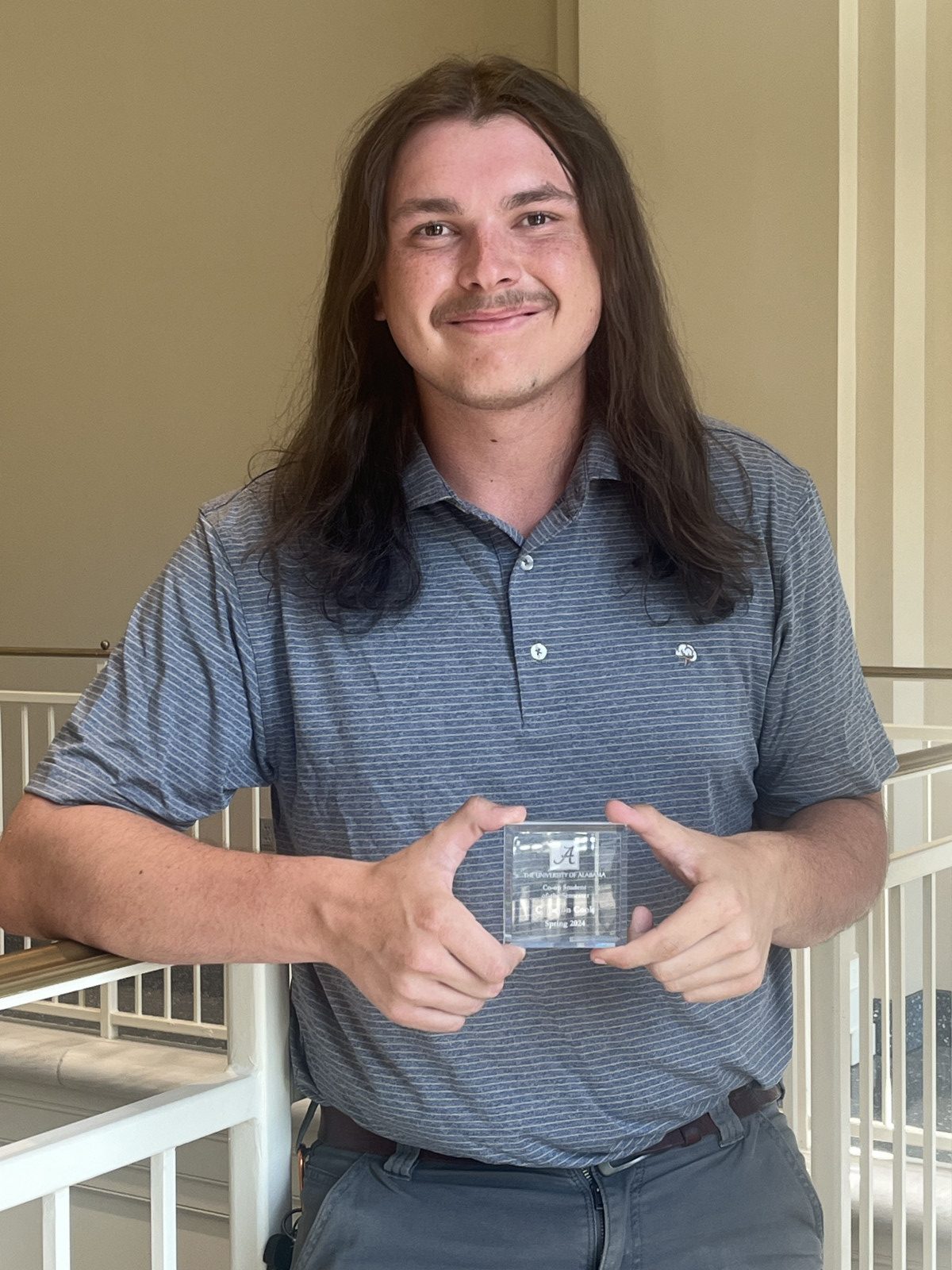 Cameron Cook holding his award.