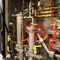 lots of mechanical parts and wires inside a machine near a wall