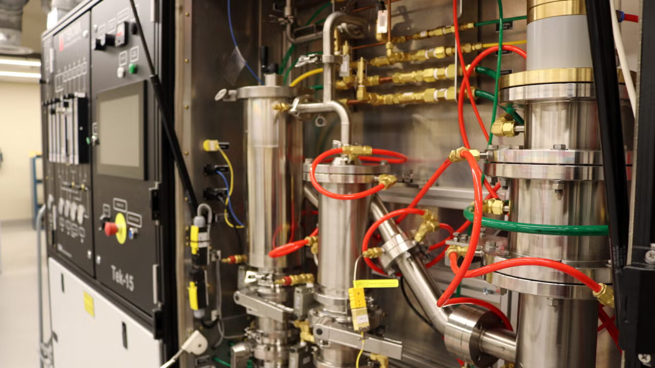 lots of mechanical parts and wires inside a machine near a wall