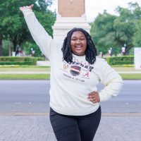 A student cheering in front of Denny Chimes