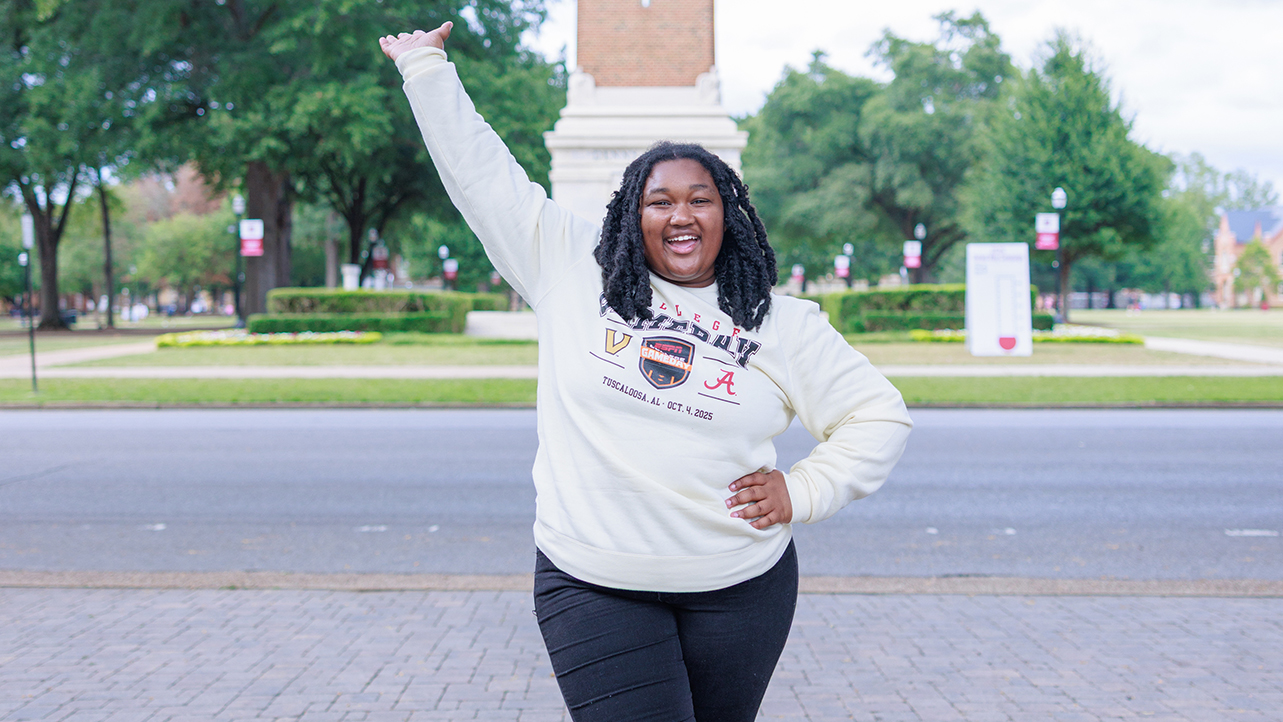 A student cheering in front of Denny Chimes