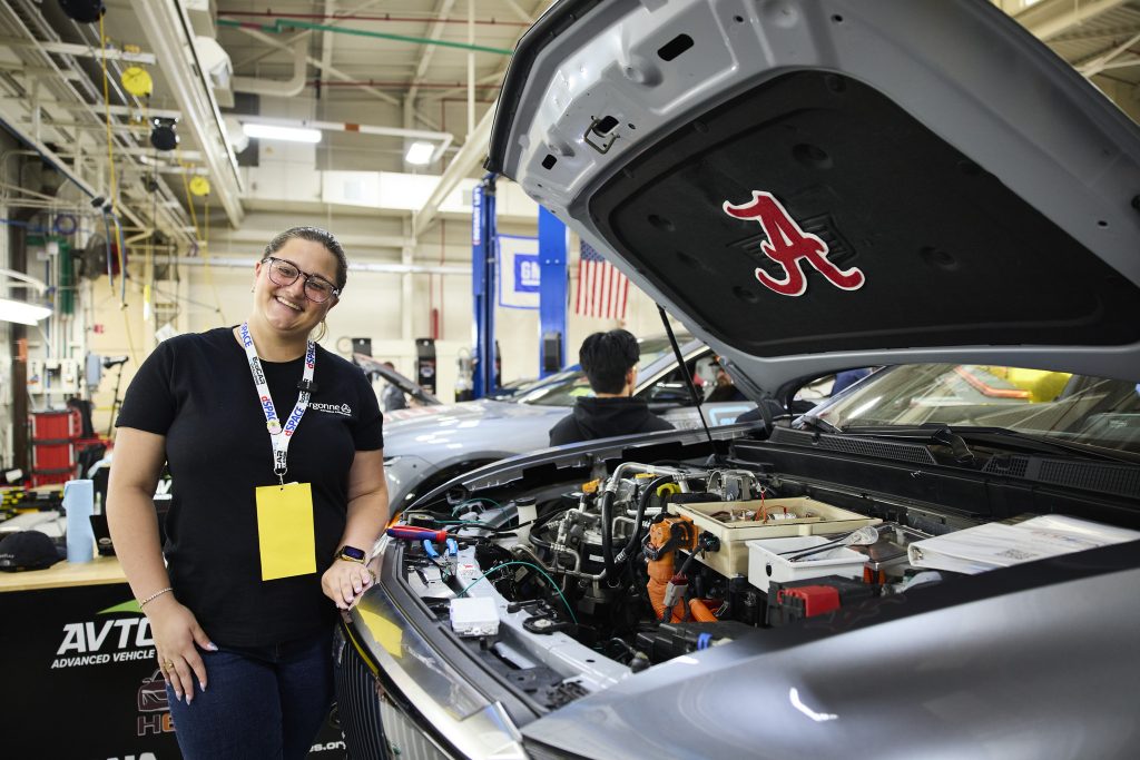 A student in glasses shows off the engine